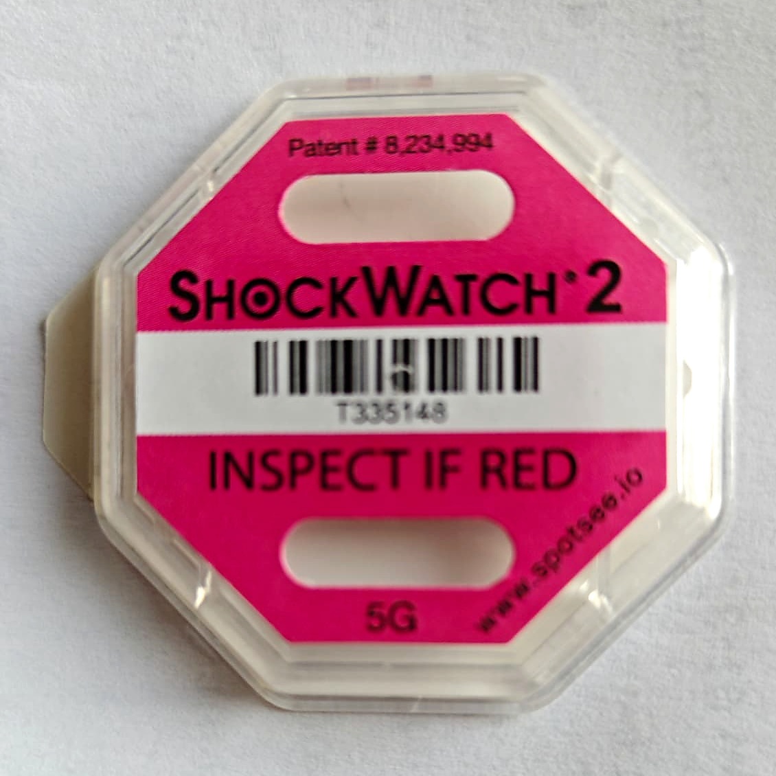 ShockWatch 2 wskaźnik wstrząsu przed zadziałaniem — białe okienko, napis INSPECT IF RED